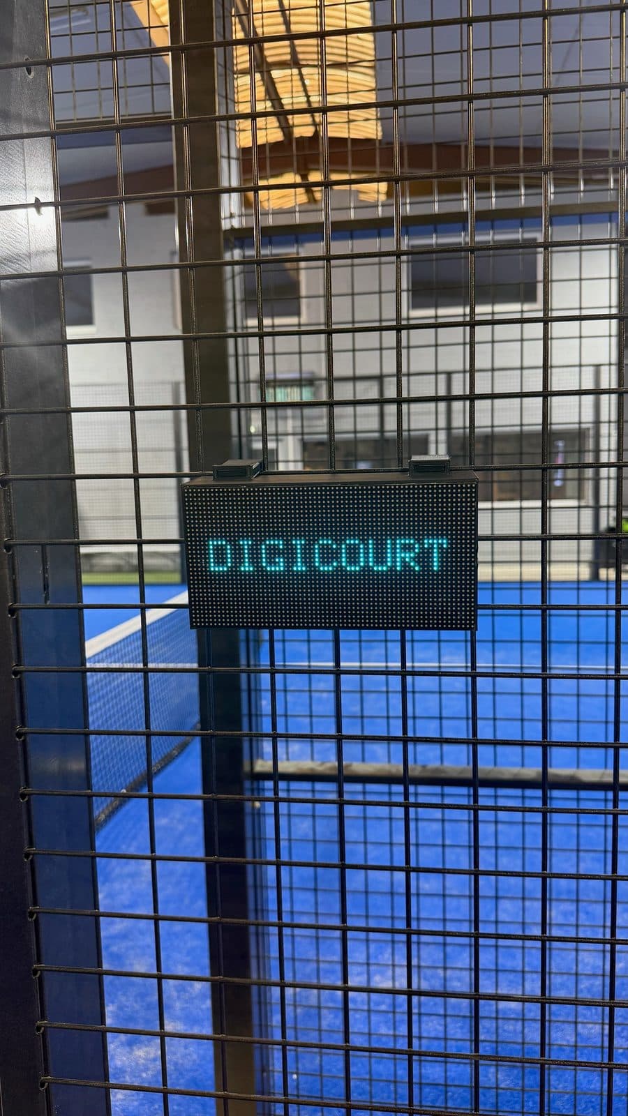 DigiCourt fixé sur la grille d'un terrain de padel